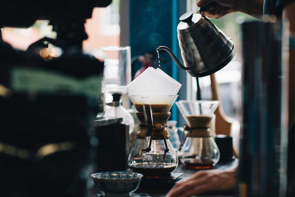 A coffee slow bar with several Chemex coffee makers being brewed
