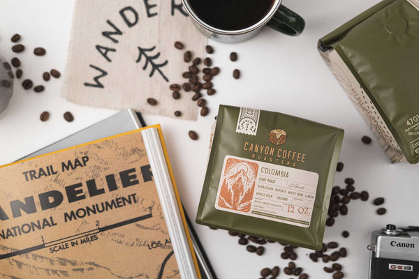 Flat lay of Canyon Coffee Roasters coffee with a cup of coffee and travel gear